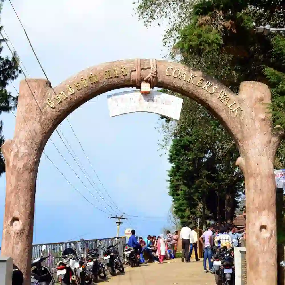The rustic entrance arch of Coaker's Walk in Kodaikanal, a scenic paved pedestrian path with stunning mountain views.